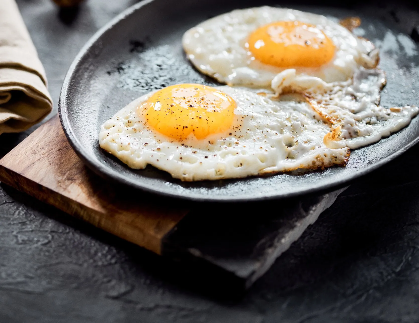 Dos huevos estrellados en sartén de hierro