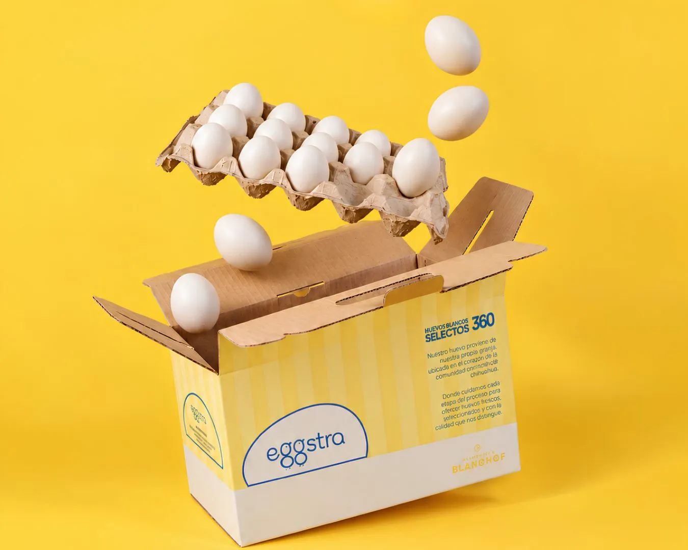 Caja de Eggstra abierta con huevos blancos volando sobre fondo amarillo